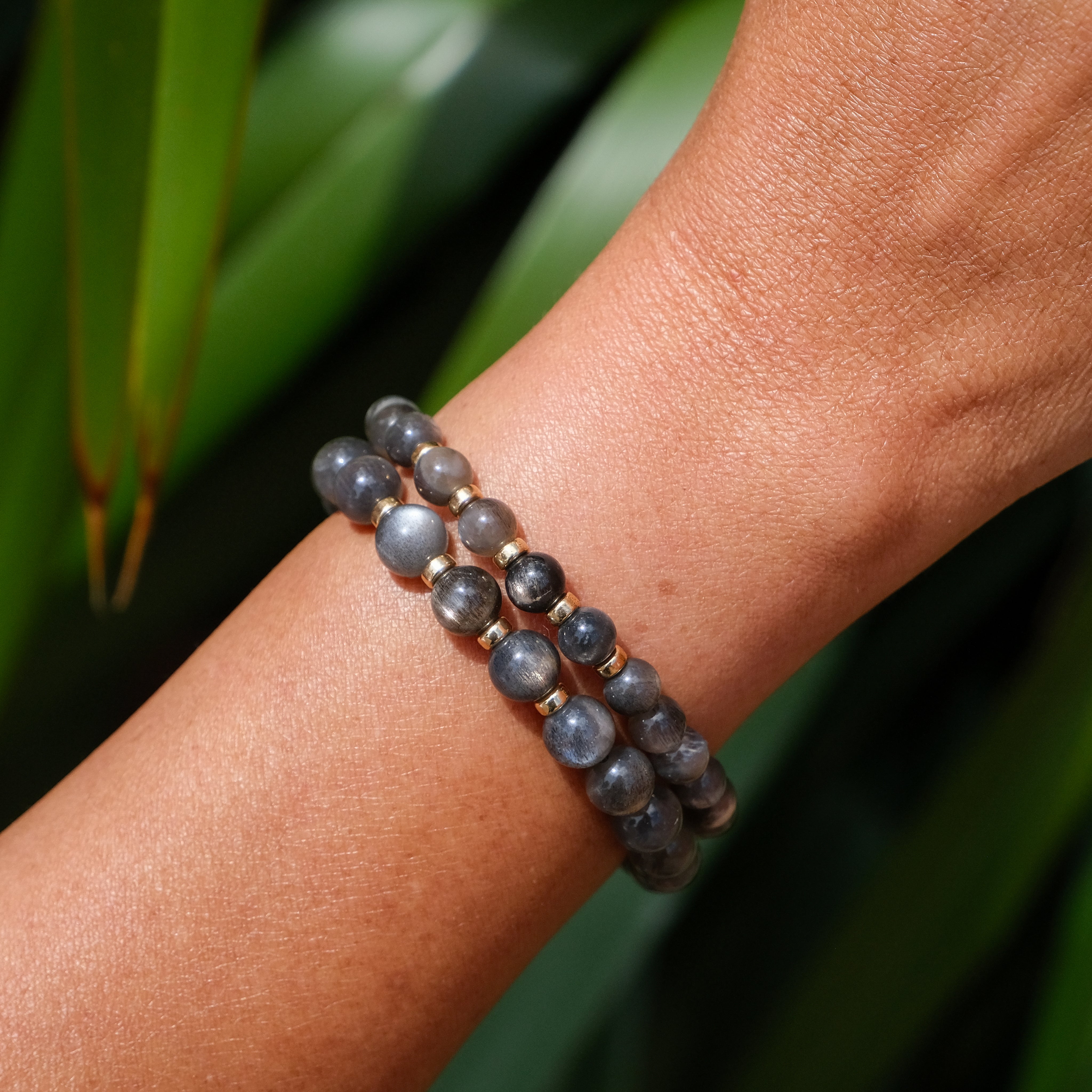 A model wearing a 6mm and an 8mm black moonstone bracelet