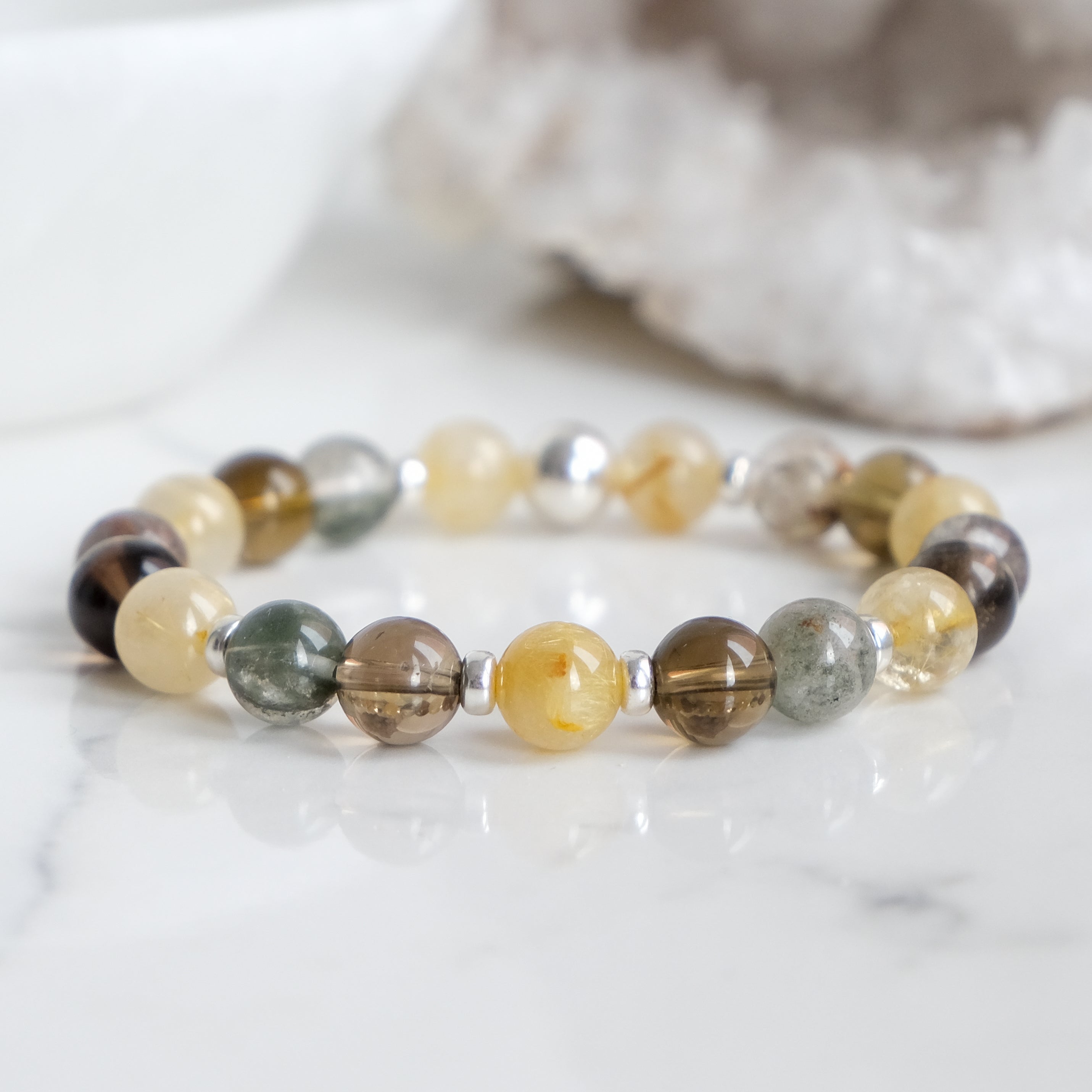 A rutilated quartz, smoky quartz and green phantom quartz bracelet with 925 sterling silver accessories