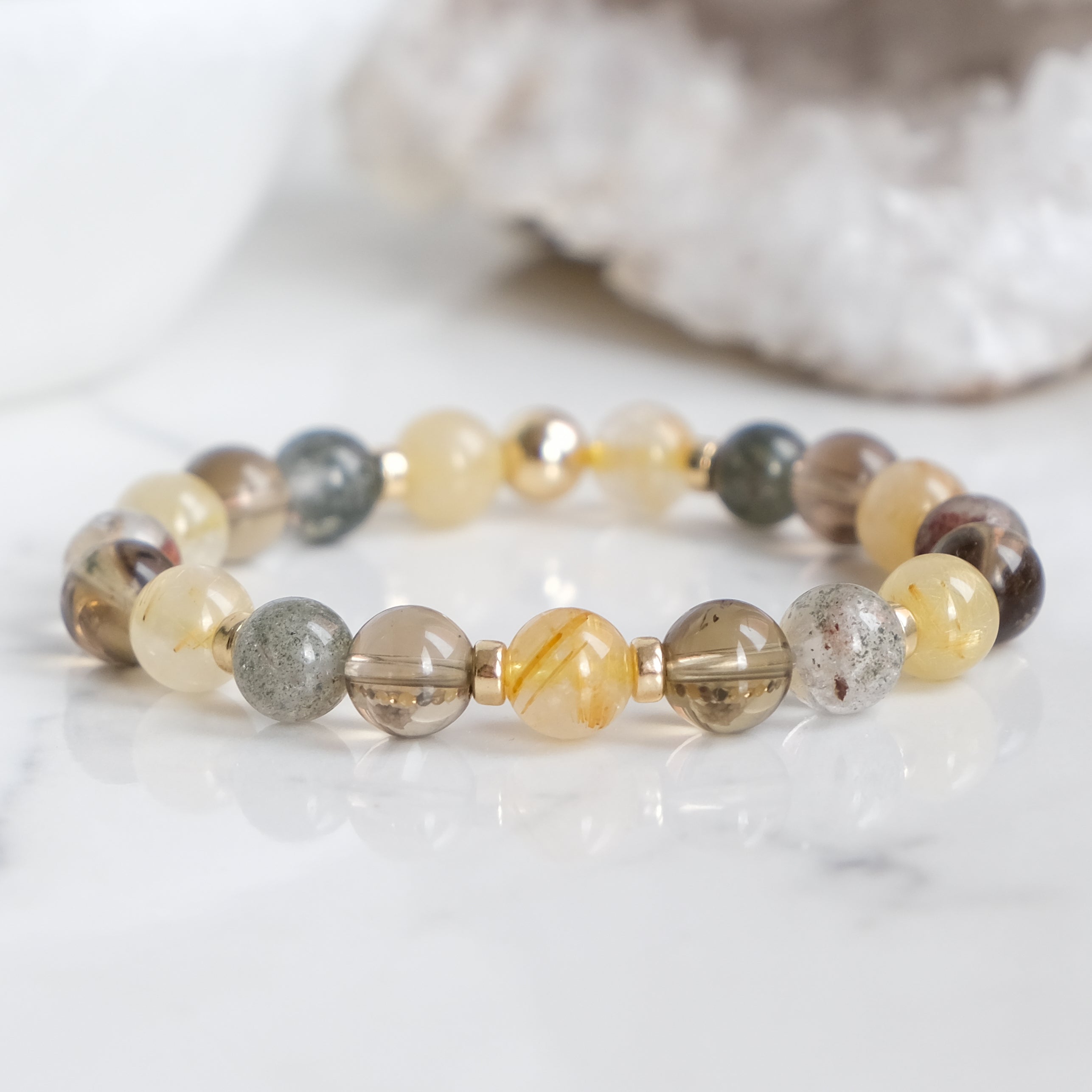 A rutilated quartz, smoky quartz and green phantom quartz bracelet with gold filled accessories