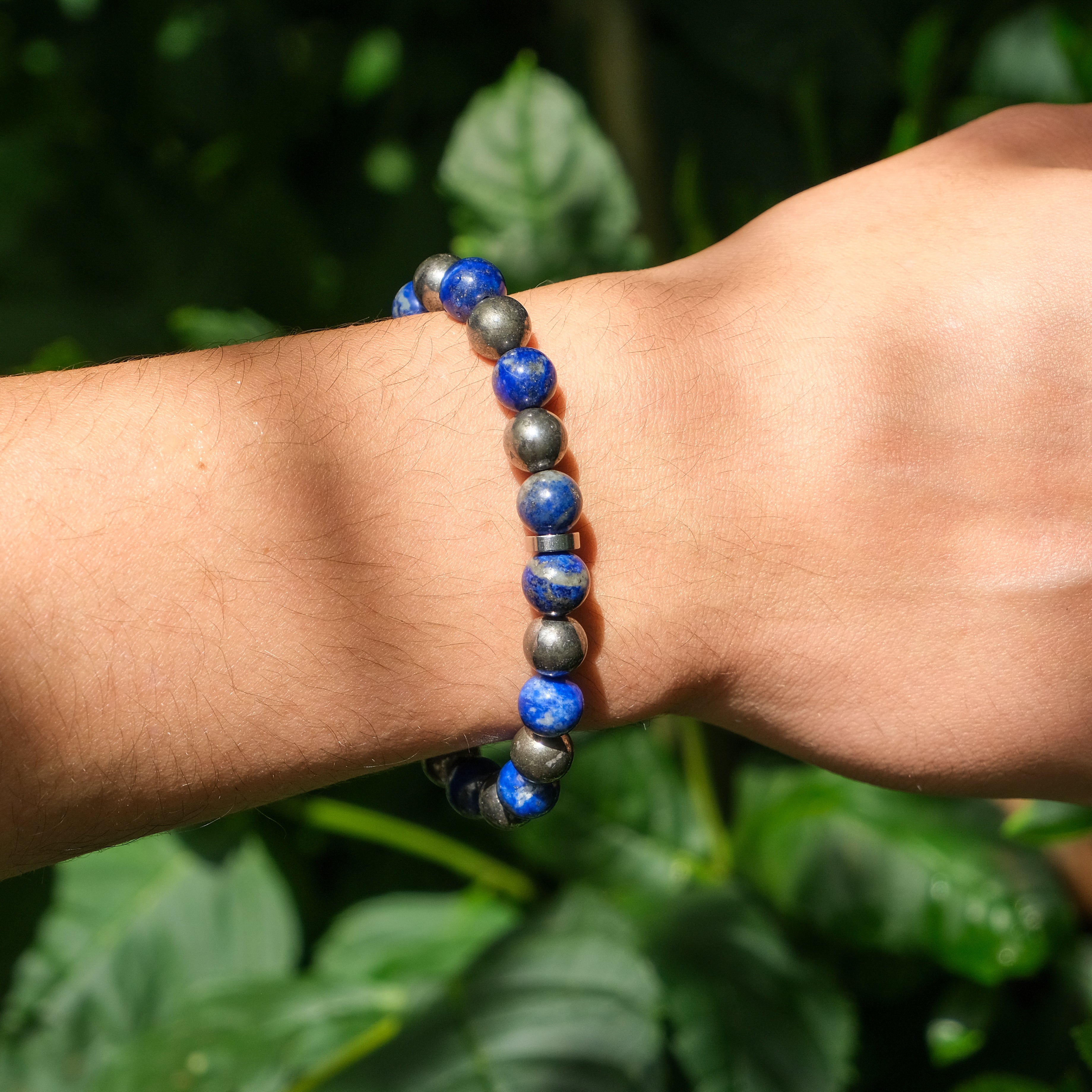 A model wearing a 8mm lapis lazuli and pyrite gemstone bracelet with stainless steel accessories