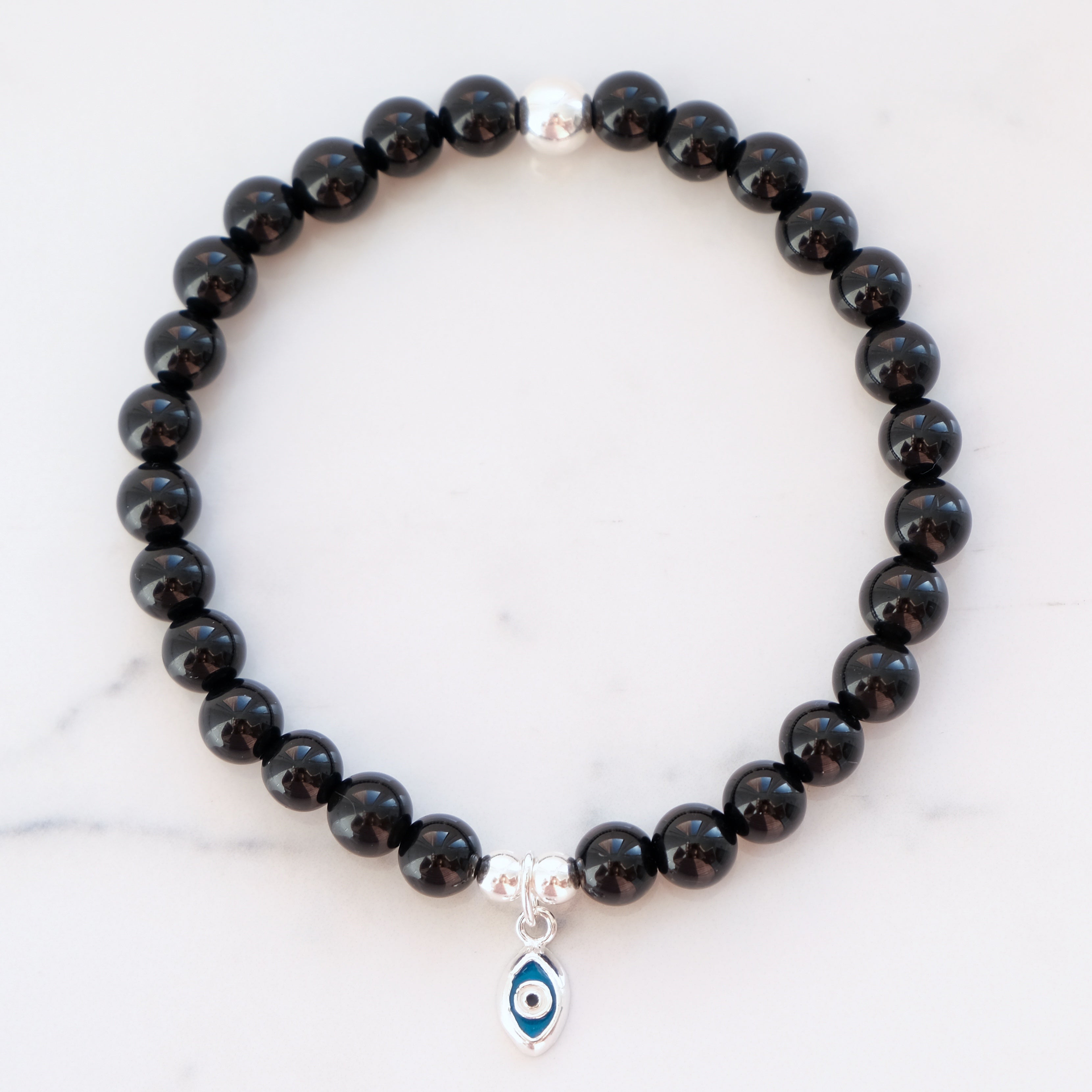 Black onyx gemstone bracelet in 6mm with silver evil eye charm