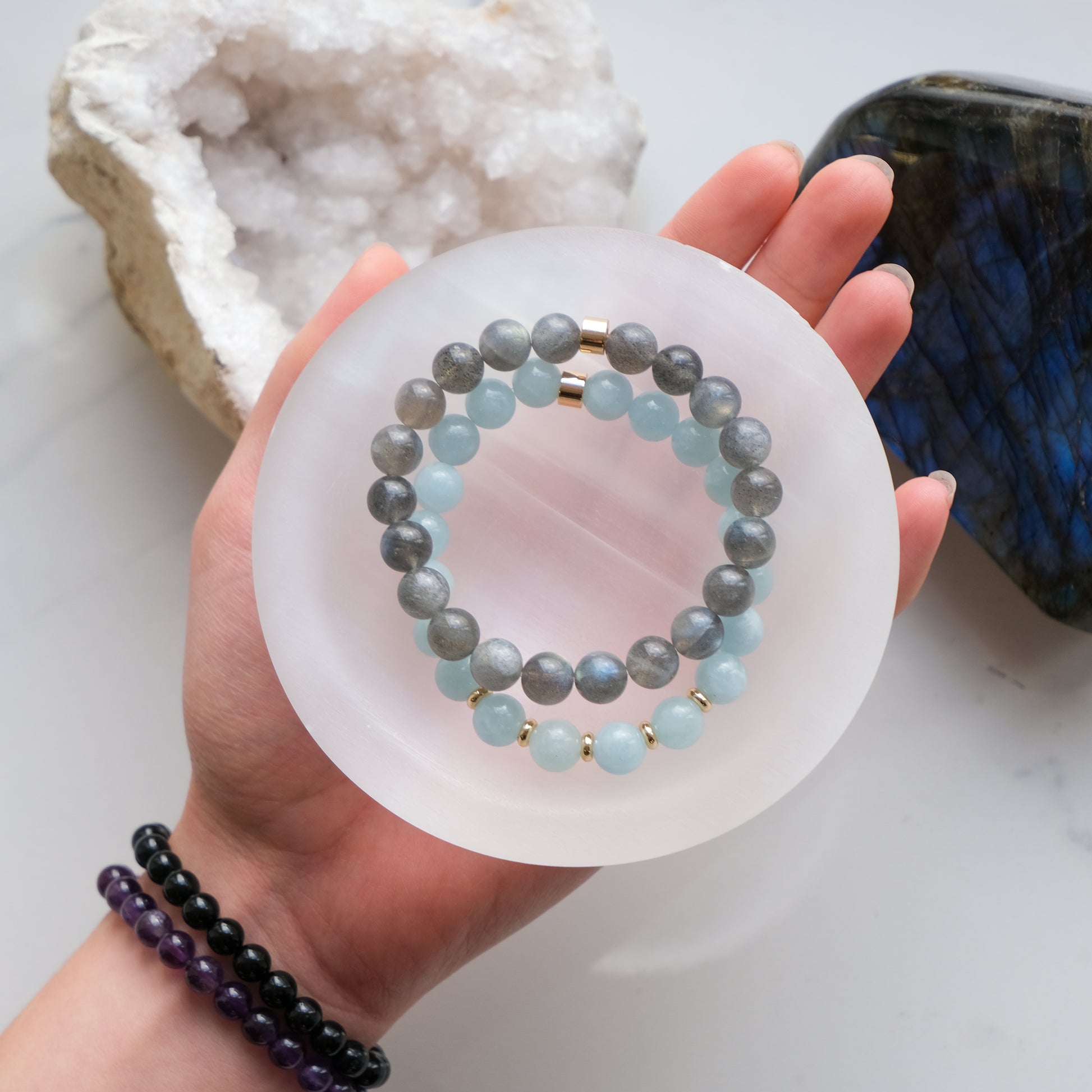 A selenite crystal charging bowl with crystal bracelets inside