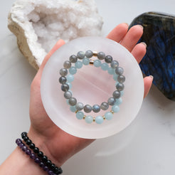 A selenite crystal charging bowl with crystal bracelets inside