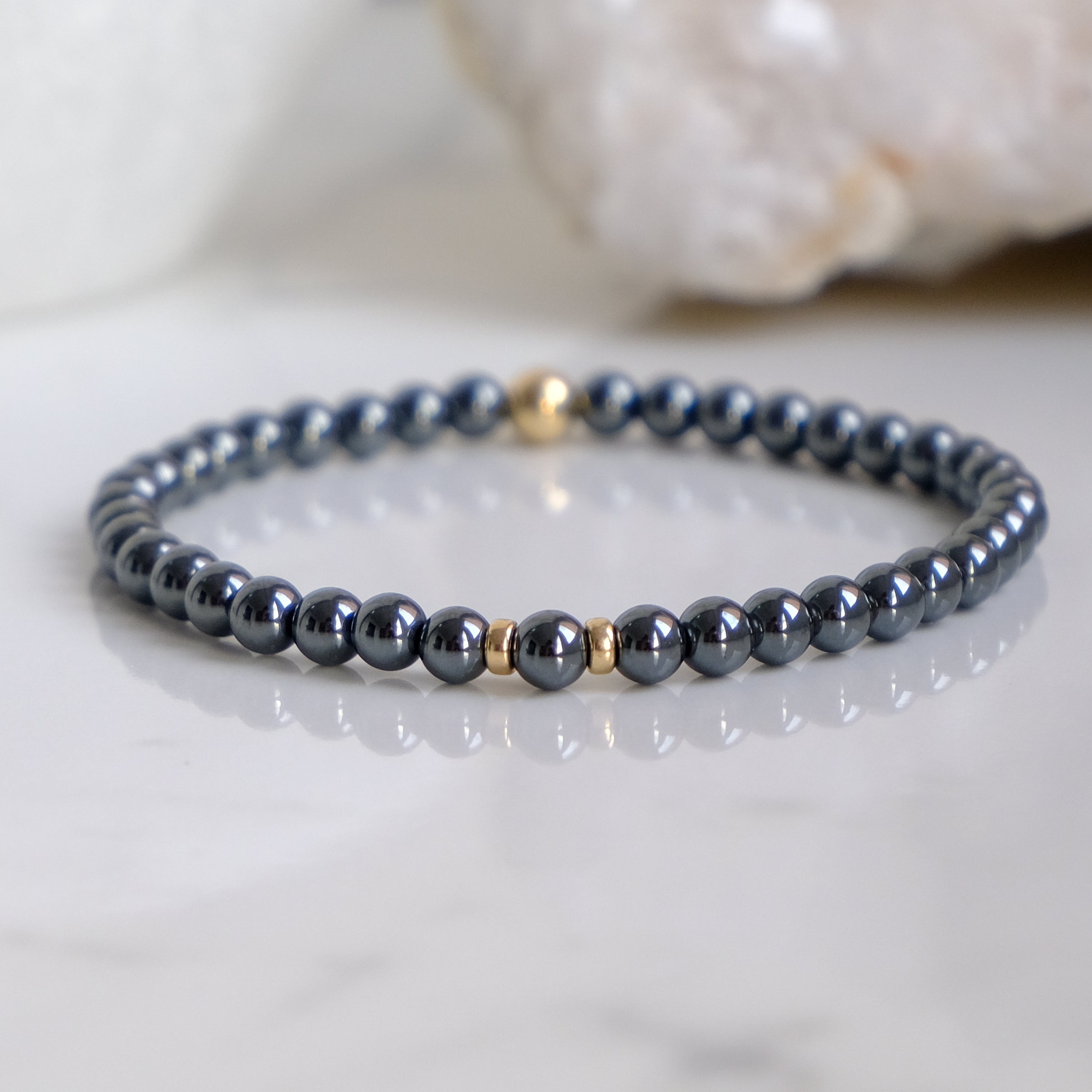 A 4mm hematite gemstone bracelet with gold accessories