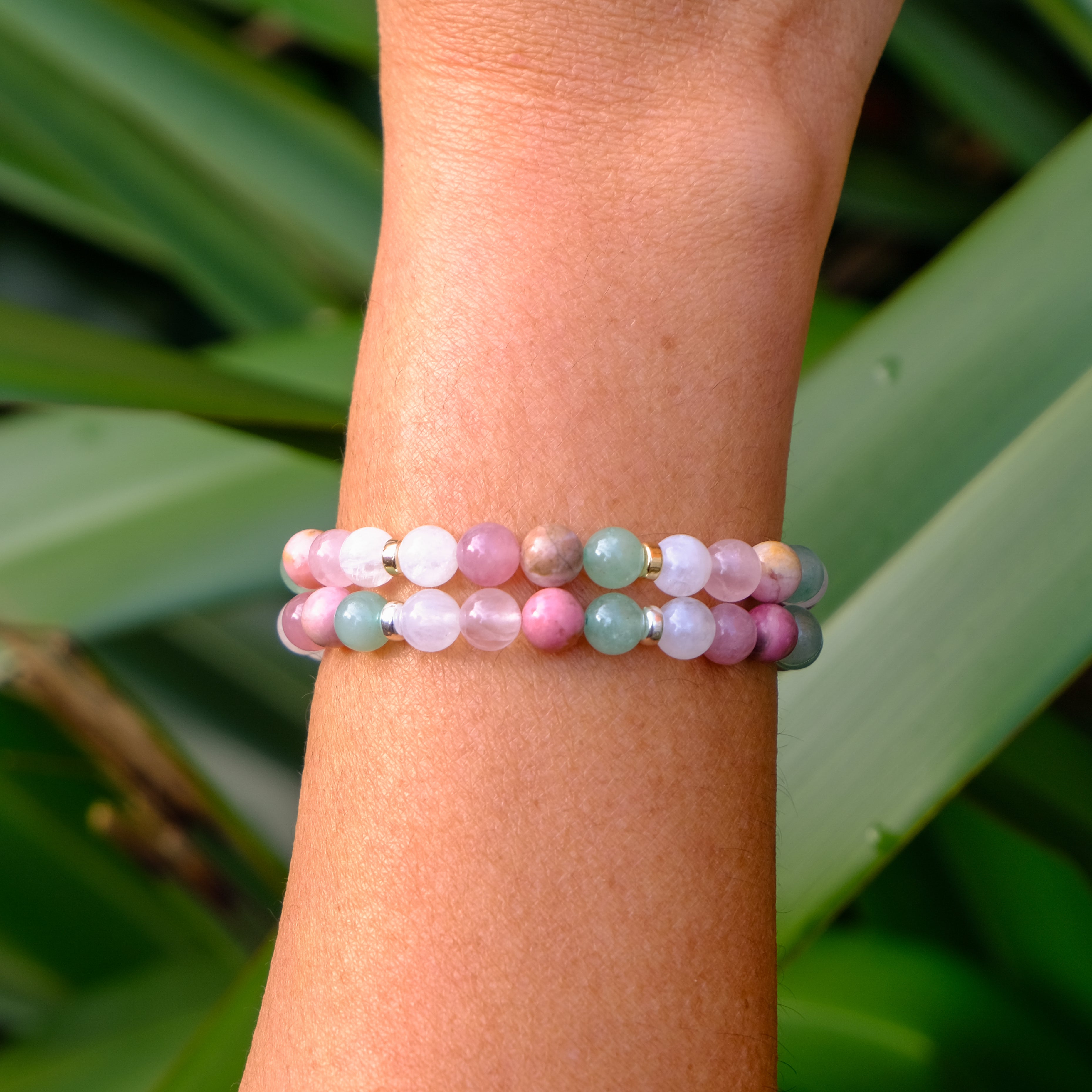 Two Heart healing gemstone bracelets worn on a model's wrist